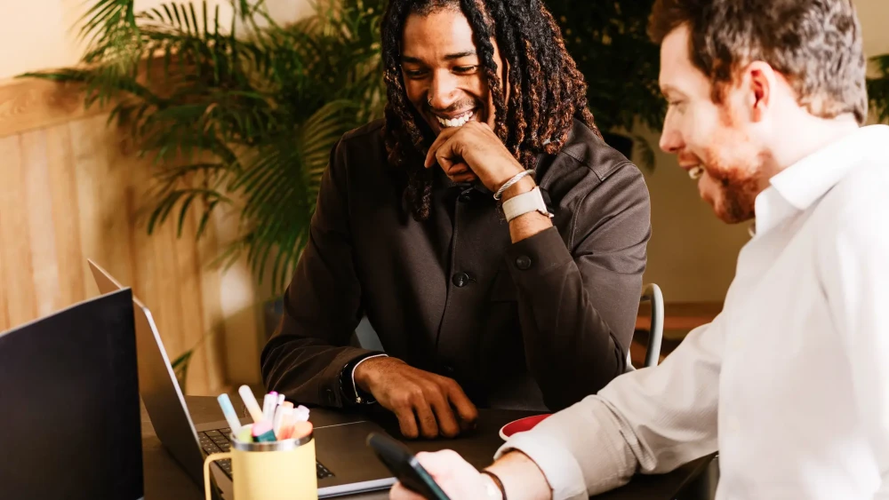 Two men very pleased with interacting with their mobile and desktop Amazon Seller Assistant