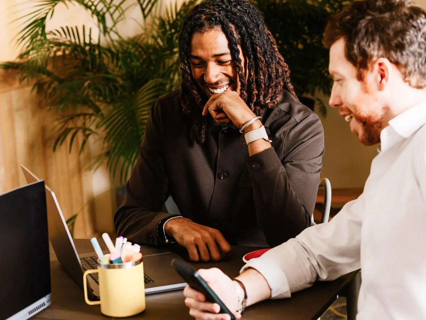 Two men very pleased with interacting with their mobile and desktop Amazon Seller Assistant